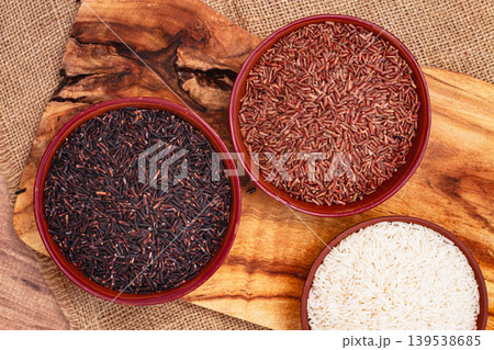 set of red and black and white rice, in a bowl, on a wooden surface, rustic style, top view 139538685
