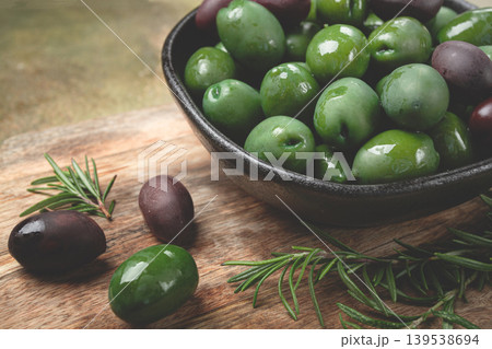 Chalkidiki olives, classic Greek green olives, in a bowl on a cutting board, top view, without people, Chalkidiki olives, classic Greek green olives, in a bowl on a cutting board, top view, without people, 139538694