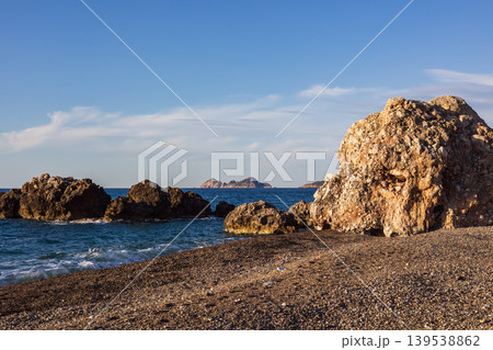 Large rock formation on a pebble beach at mediterranean coast Large rock formation on a pebble beach at mediterranean coast 139538862