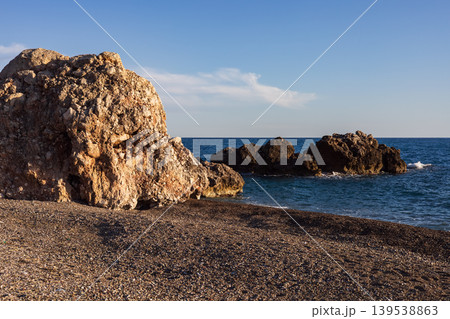 Large rock formation on a pebble beach at mediterranean sea Large rock formation on a pebble beach at mediterranean sea 139538863