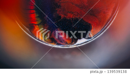 Colorful ink rainbow. Sparkling fluid. Defocused orange blue purple glitter particles spreading on abstract vibrant creative background. 139539138