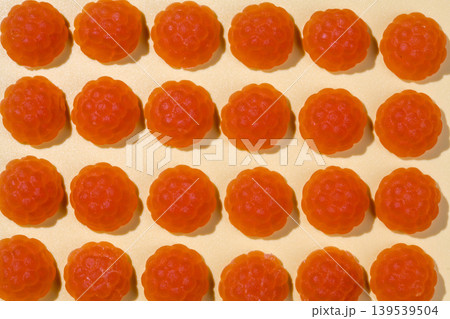 Jelly gummies close-up, fruit vitamins raspberry shaped, food supplements.Orange vitamins candies, top view Jelly gummies close-up, fruit vitamins raspberry shaped, food supplements.Orange vitamins candies, top view 139539504