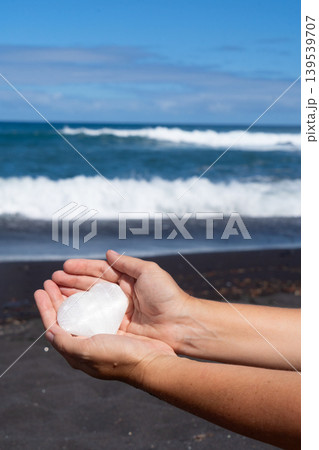 woman meditating on beach shore and holding crystal heart woman meditating on beach shore and holding crystal heart 139539707