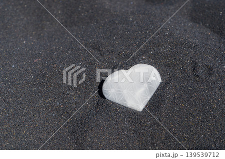 meditating on beach shore and holding crystal heart meditating on beach shore and holding crystal heart 139539712