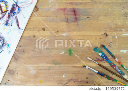 An Artistic Workspace Featuring an Array of Colorful Paint Brushes Spread Out on a Rustic Wooden Table An Artistic Workspace Featuring an Array of Colorful Paint Brushes Spread Out on a Rustic Wooden Table 139539772