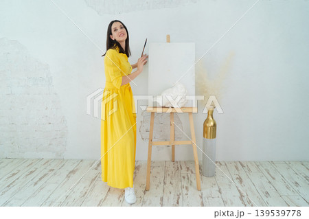 A Joyful Artist Proudly Showcasing Their Colorful Paint Brushes in a Bright and Inspiring Studio Environment 139539778