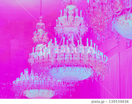 Elegant crystal chandeliers illuminated in vibrant pink hues, creating a luxurious ambiance in a grand space, showcasing intricate designs and sparkling details 139539836