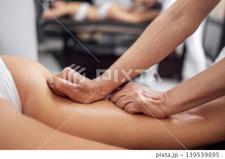 Masseuse makes anti cellulite massage of buttocks, thighs and legs to her client 139539895
