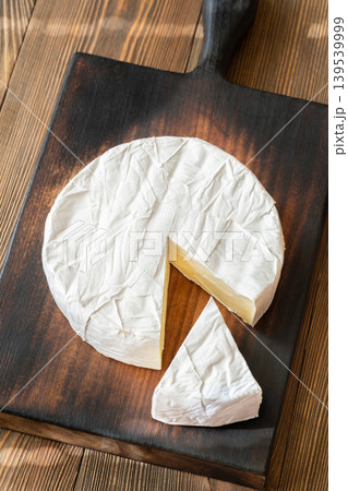 Creamy Camembert Cheese Wheel With Slice Removed On Rustic Wooden Board Display Creamy Camembert Cheese Wheel With Slice Removed On Rustic Wooden Board Display 139539999