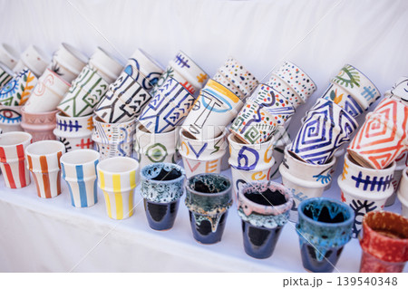 Colorful ceramic pots arranged in a vibrant display, showcasing intricate designs and patterns, highlighting craftsmanship and artistic expression in pottery 139540348
