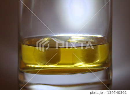 Bottom of Glass Cup Of Scotch Whisky With Ice Cubes Closeup Bottom of Glass Cup Of Scotch Whisky With Ice Cubes Closeup 139540361