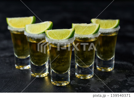 Tequila shot with lime slices . Mexican tequila on a dark table, selective focus. 139540371