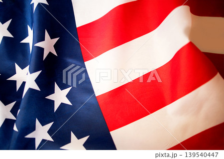 American flag with red and white stripes and white stars on a blue field, fabric texture visible, symbolizing patriotism and national identity in the United States American flag with red and white stripes and white stars on a blue field, fabric texture visible, symbolizing patriotism and national identity in the United States 139540447