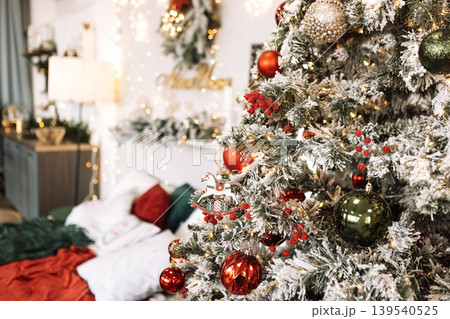 Festively decorated Christmas tree adorned with colorful ornaments, surrounded by cozy holiday decor, creating a warm and inviting atmosphere for seasonal celebrations 139540525