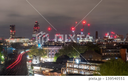 Nighttime London Skyline with Construction Cranes Urban Lights and Modern City Development Nighttime London Skyline with Construction Cranes Urban Lights and Modern City Development 139540551