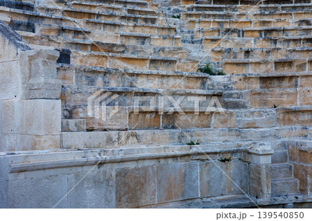 Ancient stone seating rows of a historic amphitheater ruin in daylight Ancient stone seating rows of a historic amphitheater ruin in daylight 139540850