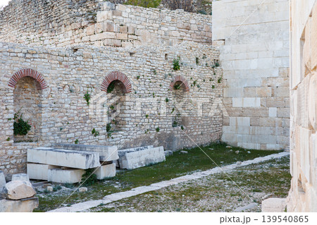 Ancient stone wall with arched niches in a historical archaeological 139540865