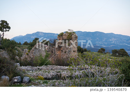 Ancient stone wall ruins in a landscape with mountain ranges at sunset Ancient stone wall ruins in a landscape with mountain ranges at sunset 139540870