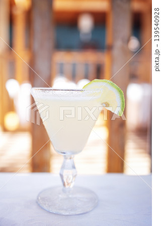Refreshing cocktail served in a crystal glass with a lime wedge, showcasing vibrant colors and textures, perfect for summer gatherings and celebrations Refreshing cocktail served in a crystal glass with a lime wedge, showcasing vibrant colors and textures, perfect for summer gatherings and celebrations 139540928