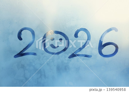 Handwritten blue arabic numerals 2026 is twenty twenty-six with doodle smiling face on frozen window, copy space Handwritten blue arabic numerals 2026 is twenty twenty-six with doodle smiling face on frozen window, copy space 139540958