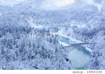 水際まで雪が積もるほど水位が低かった頃の只見川を渡る只見線の3両編成の気動車 水際まで雪が積もるほど水位が低かった頃の只見川を渡る只見線の3両編成の気動車 139541105