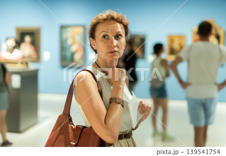 Woman looks at hall of paintings and sculptures Woman looks at hall of paintings and sculptures 139541754