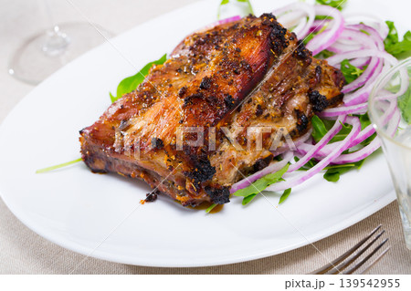 Grilled rack of pork with arugula and onion Grilled rack of pork with arugula and onion 139542955