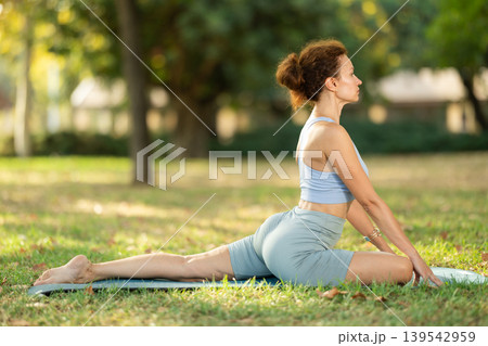 Different yoga poses performed by a slender woman in summer garden Different yoga poses performed by a slender woman in summer garden 139542959