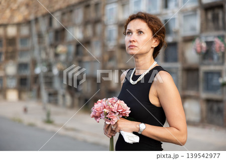 Woman brought flowers to the cemetery and cries over the death of beloved relative 139542977