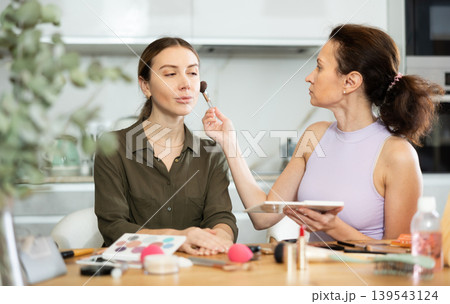 Female makeup artist brushing blush onto woman face 139543124