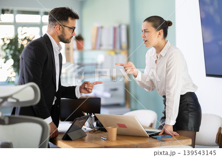 Man and girl colleagues are arguing excitedly in office Man and girl colleagues are arguing excitedly in office 139543145