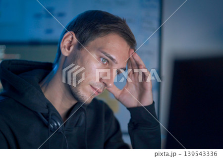 Software developer feeling stressed while working on programming code late at night Software developer feeling stressed while working on programming code late at night 139543336