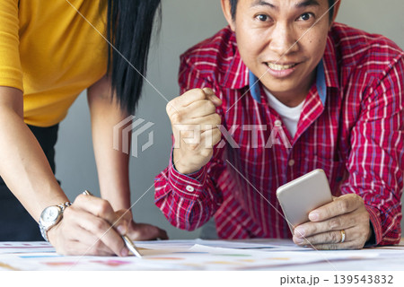 Happy success business woman partner working together in company office corporate executive teamwork. Meeting Executive Asian business woman using laptop office desk with fist arm raised win happiness Happy success business woman partner working together in company office corporate executive teamwork. Meeting Executive Asian business woman using laptop office desk with fist arm raised win happiness 139543832