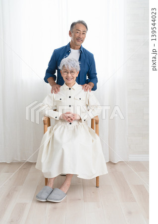 椅子に座る女性と側に立つ男性　ライフスタイルイメージ 139544023
