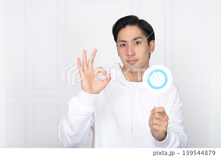 正解マークを持つ笑顔の男性 正解マークを持つ笑顔の男性 139544879