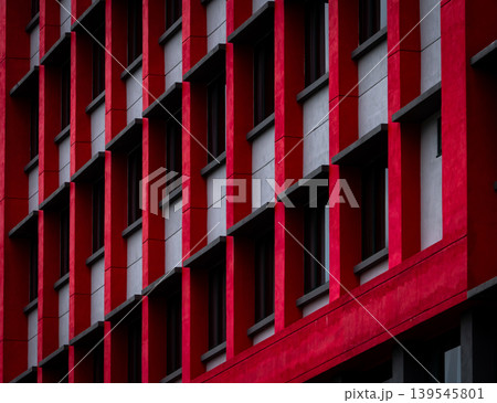 Glass window of skyscraper office building with red and white concrete wall. Exterior commercial building. Modern architecture design. Facade of modern business building. Concrete and glass building. Glass window of skyscraper office building with red and white concrete wall. Exterior commercial building. Modern architecture design. Facade of modern business building. Concrete and glass building. 139545801