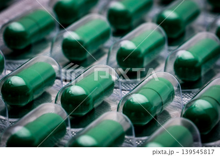 Andrographis paniculata extract for treatment common cold and sore throat. Standardized herbal medicine capsule pills in pack. Full frame of green capsule pills. Alternative medicine concept. Andrographis paniculata extract for treatment common cold and sore throat. Standardized herbal medicine capsule pills in pack. Full frame of green capsule pills. Alternative medicine concept. 139545817