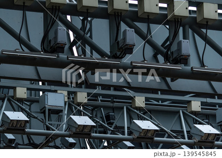 Electronic road pricing system in Singapore using open road tolling technology on urban expressway, vehicles passing gantry without stopping while digital sensors and cameras manage congestion. 139545845