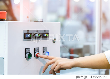 Engineer hand pressing red shutdown button on temperature control cabinet, industrial heat regulation system in factory. Safety operation, automation monitoring and equipment protection. Engineer hand pressing red shutdown button on temperature control cabinet, industrial heat regulation system in factory. Safety operation, automation monitoring and equipment protection. 139545938