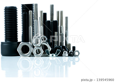 Metal bolts and nuts on white background. Fasteners equipment. Hardware tools. Stud bolt, hex nuts, and hex head bolts in workshop. Threaded fastener use in automotive engineering. Hexagonal bolt. 139545960