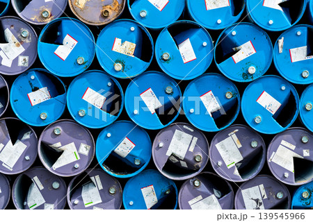 Old chemical barrels. Blue and purple oil drum. Steel oil tank. Toxic waste warehouse. Hazard chemical barrel with warning label. Industrial waste in metal drum. Hazard waste storage in factory. 139545966