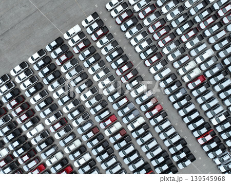 Aerial view of new cars stock at factory parking lot. Above view cars parked in a row. Automotive industry. Logistics business. Import or export new cars at warehouse. Big parking lot at port terminal 139545968