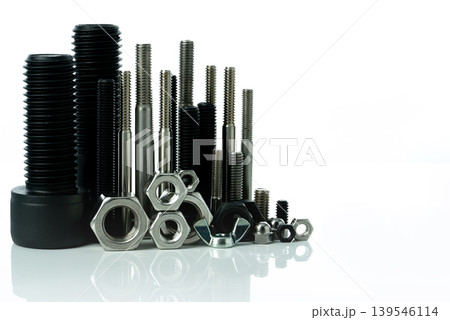 Metal bolts and nuts on white background. Fasteners equipment. Hardware tools. Stud bolt, hex nuts, and hex head bolts in workshop. Threaded fastener use in automotive engineering. Hexagonal bolt. Metal bolts and nuts on white background. Fasteners equipment. Hardware tools. Stud bolt, hex nuts, and hex head bolts in workshop. Threaded fastener use in automotive engineering. Hexagonal bolt. 139546114