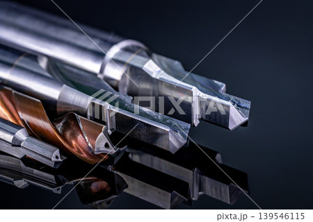 Special tools isolated on dark background. Made to order special tools. Coated step drill and reamer detail. HSS cemented carbide. Carbide cutting tool for industrial applications. Engineering tools. 139546115