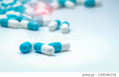 Selective focus on blue and white capsules pill on white background. Antibiotics drug resistance. Antimicrobial capsule pills. Pharmaceutical industry. Pharmacy drugstore products. Pharmaceutics. Selective focus on blue and white capsules pill on white background. Antibiotics drug resistance. Antimicrobial capsule pills. Pharmaceutical industry. Pharmacy drugstore products. Pharmaceutics. 139546139
