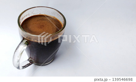 Hot black coffee in a glass cup with crema on a white background. 139546698