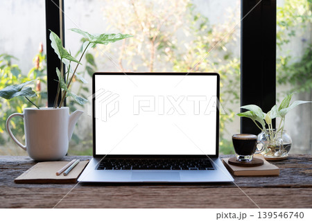 Laptop and coffee drink and devil's ivy plants, cozy indoor work space 139546740