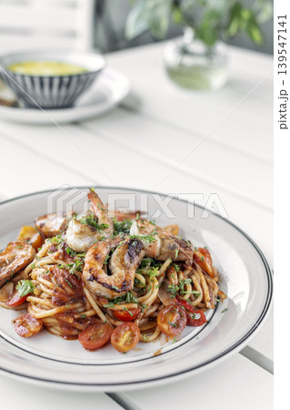 shrimp and tomato diavolo spicy spaghetti on white table at outdoor restaurant in italy 139547141