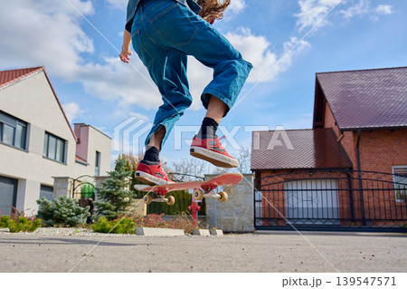 Skateboarder riding on residential street in sunny neighborhood 139547571