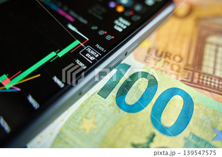 Smartphone with stock market chart on 100 euro banknote Smartphone with stock market chart on 100 euro banknote 139547575